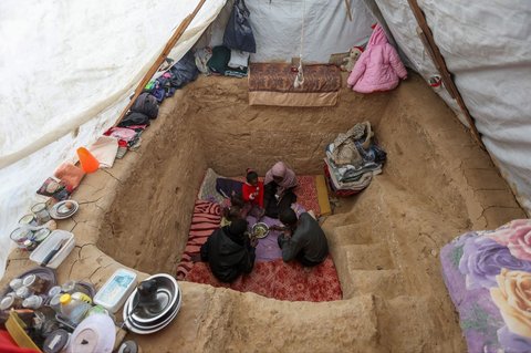 FOTO: Lelah Berkali-kali Mengungsi, Pria di Jalur Gaza Gali Lubang untuk Berlindung dari Serangan Israel