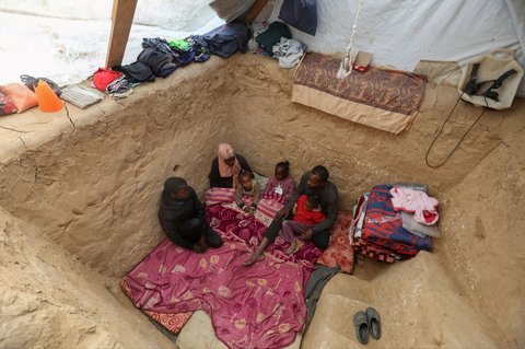 FOTO: Lelah Berkali-kali Mengungsi, Pria di Jalur Gaza Gali Lubang untuk Berlindung dari Serangan Israel