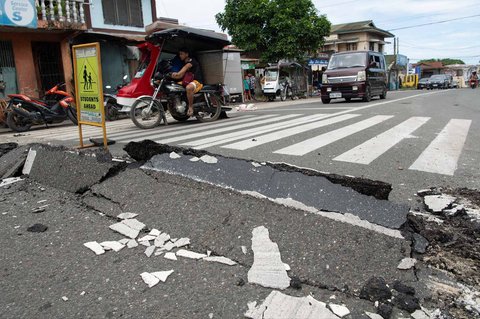 Kendaraan bermanuver melewati bagian jalan yang rusak di Kota Bogo Provinsi Cebu, Filipina, Rabu (01/10/2025).