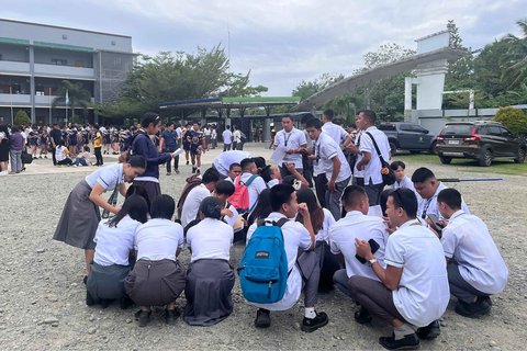 Para siswa berkumpul di luar gedung sekolah setelah gempa bumi 7,4 skala Richter di Davao de Oro, Mindanao. Filipina, Jumat (10/10/2025).