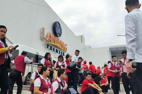 Para karyawan sebuah pusat perbelanjaan berkumpul di luar setelah gempa bumi 7,4 skala Richter di Davao de Oro, Mindanao. Filipina, Jumat (10/10/2025).