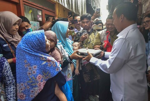 Menteri Kependudukan dan Pembangunan Keluarga sekaligus Kepala Badan Kependudukan dan Keluarga Berencana Nasional (BKKBN) Wihaji saat menyerahkan MBG kepada salah satu keluarga penerima  di Surabaya, Kamis (09/10/2025).