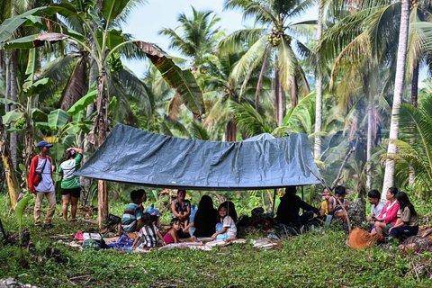Warga berkumpul di tenda darurat di luar rumah mereka di Manay, Provinsi Davao Oriental, Sabtu, (11/10/2025).