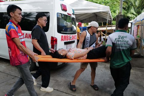 Warga membawa seorang perempuan dengan tandu di Kota Manay yang dilanda gempa bumi, Provinsi Davao Oriental, Filipina selatan, Sabtu, (11/10/2025).