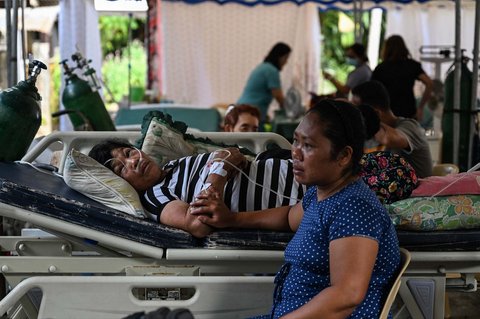 Para pasien menunggu di luar rumah sakit yang rusak di Manay, Provinsi Davao Oriental, Sabtu, (11/10/2025).
