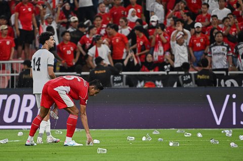Pemain Indonesia Rizky Ridho memunguti gelas air yang dilempar suporter saat pertandingan babak keempat Grup B Kualifikasi Piala Dunia 2026 zona Asia antara Irak dan Indonesia di Stadion Alinma Bank, King Abdullah Sports City, Jeddah, Arab Saudi, Sabtu, Sabtu, (11/10/2025) waktu setempat.