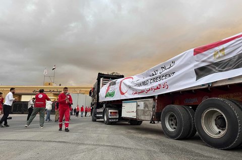 Truk-truk bermuatan bantuan kemanusiaan terparkir menunggu akses ke Jalur Gaza di pertabatasan Mesir, Minggu (12/10/2025).