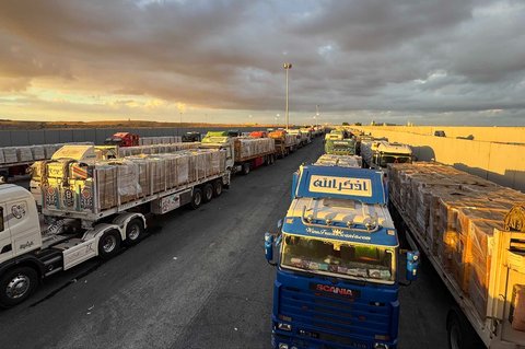 Truk-truk bermuatan bantuan kemanusiaan terparkir menunggu akses ke Jalur Gaza di pertabatasan Mesir, Minggu (12/10/2025).