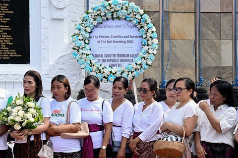 Warga berkumpul untuk berdoa di tugu peringatan bagi mereka yang gugur dalam peringatan 23 tahun bom Bali 2002 di Kuta,  Bali, Indonesia, Minggu (12/10/2025).