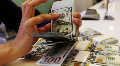 Karyawan menunjukkan uang dolar AS dan rupiah di Jakarta, Rabu (30/12/2020). Nilai tukar rupiah di pasar spot ditutup menguat 80 poin atau 0,57 persen ke level Rp 14.050 per dolar AS. (Liputa