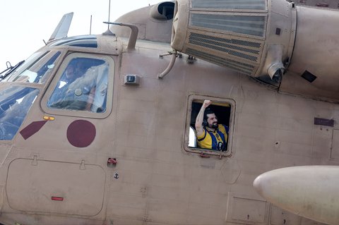 Salah satu sandera Israel yang dibebaskan dan sebelumnya ditawan di Gaza Ziv Berman, memberi isyarat dari jendela helikopter militer CH-53 Sea Stallion Israel di Pusat Medis Sheba Tel-HaShomer di Ramat Gan, Senin (13/10/2025).