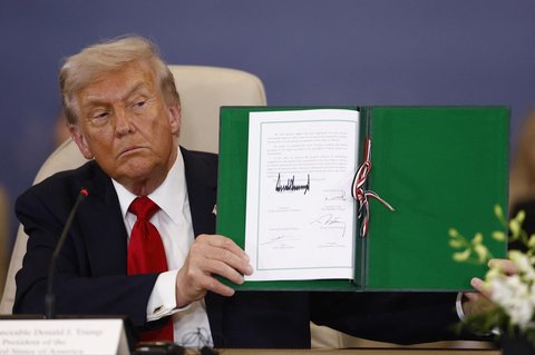 Presiden AS Donald Trump menunjukkan dokumen yang telah ditandatangani pada KTT Perdamaian Gaza di Sharm El-Sheikh, Mesir, Senin (13/10/2025) waktu setempat.