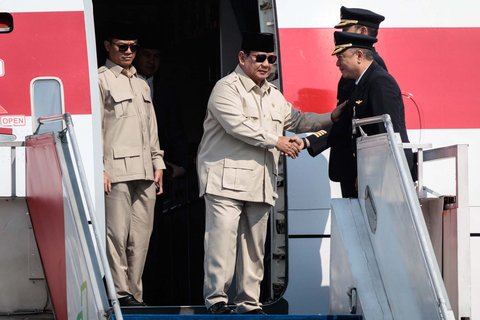Presiden Indonesia, Prabowo Subianto berjabat tangan dengan para pilot saat turun dari pesawat kepresidenan setibanya di Pangkalan Angkatan Udara Halim Perdanakusuma, Jakarta, Selasa (14/10/2025).