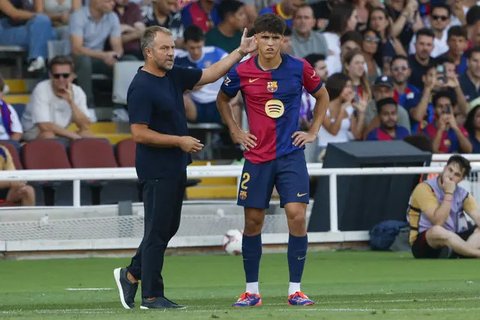 Pelatih Barcelona, Hansi Flick saat memberikan instruksi dari pinggir lapangan bersama pemainnya Pau Cubarsi. (AP Photo/Joan Monfort)