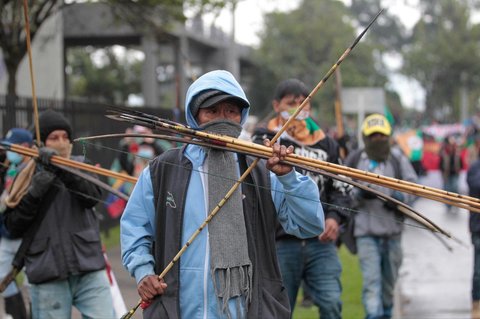 Para demonstran bersiap menembakkan panah ke arah petugas polisi di dekat pintu masuk Kedutaan Besar AS di Bogota, Kolombia, Jumat (17/10/2025) waktu setempat.
