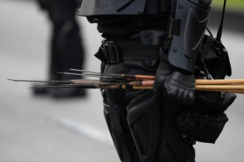 Polisi menyita anak panah yang ditembakkan oleh pengunjuk di dekat pintu masuk Kedutaan Besar AS di Bogota, Kolombia, Jumat (17/10/2025) waktu setempat.