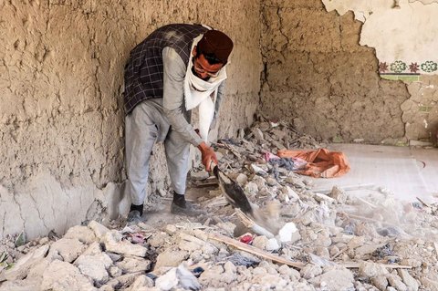 Seorang warga Afghanistan membersihkan sisa-sisa rumah yang rusak akibat serangan udara Pakistan di distrik Urgun, provinsi Paktika, Afghanistan timur, Sabtu,  (18/10/2025).