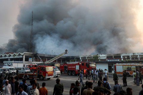 Petugas pemadam kebakaran berupaya memadamkan kebakaran yang terjadi di bagian kargo Bandara Internasional Hazrat Shahjalal di Dhaka,  Sabtu (18/10/2025) malam.