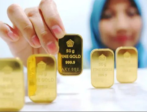 Petugas menunjukan emas batangan di kantor BNI Syariah, Jakarta, Senin (30/11). Harga jual-beli kembali (buyback) emas Antam turun Rp 1.000 usai akhir pekan kemarin naik di tengah turunnya ha