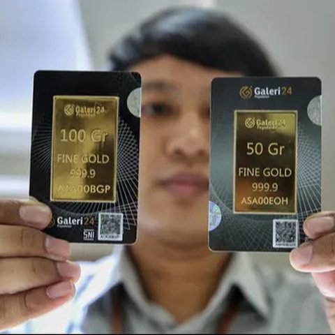 Petugas menunjukan emas batangan di kantor BNI Syariah, Jakarta, Senin (30/11). Harga jual-beli kembali (buyback) emas Antam turun Rp 1.000 usai akhir pekan kemarin naik di tengah turunnya ha