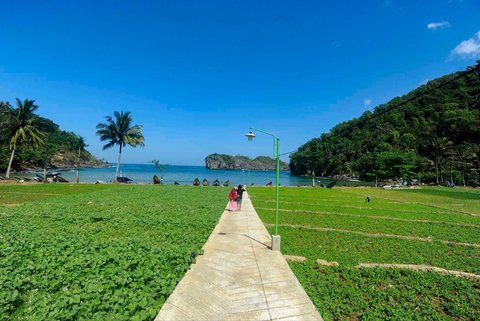 Pengunjung berjalan ke arah Pantai Kuyon sebelum melannjutkan berjalan  ke arah Lembah Batu Pawon di Dusun Nglumpang, Panggul, Trenggalek, Jawa Timur.