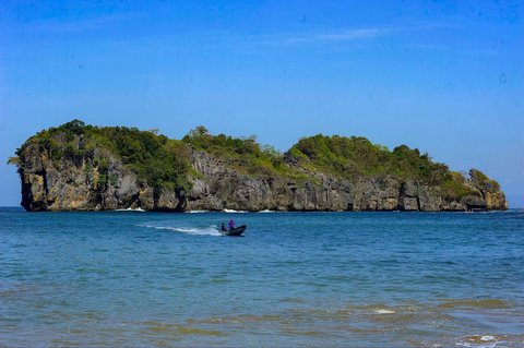Perahu nelayan melintas di kawasan Pantai Kuyon di Dusun Nglumpang, Panggul, Trenggalek, Jawa Timur.