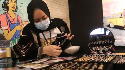 Pelanggan melihat perhiasan emas yang tersusun dalam etalase di Galeri 24, Jakarta, Selasa (13/9/2022). Selain emas batangan, Antam juga menjual bentuk lain seperti koin dinar, dirham, mau