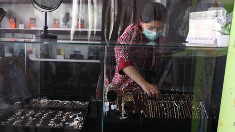 Salah satu karyawan menunjukan emas batang di Galeri 24 Pegadaian, Jakarta, Kamis (12/9/2024). (Liputan6.com/Angga Yuniar)