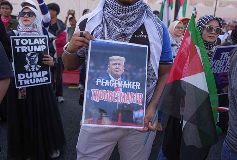 Para demonstran memegang spanduk saat demonstrasi menentang kehadiran Presiden AS Donald Trump di KTT ASEAN di Kuala Lumpur, Malaysia, Minggu (26/20/2025).