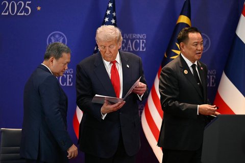 Presiden AS Donald Trump (tengah) melihat sebuah dokumen bersama Perdana Menteri Kamboja Hun Manet (kiri) dan Perdana Menteri Thailand Anutin Charnvirakul dalam upacara penandatanganan perdamian di sela-sela KTT ASEAN di Kuala Lumpur, Malaysia, Minggu (26/10/2025).