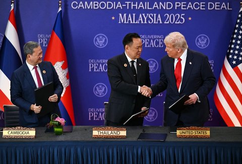 Perdana Menteri Kamboja Hun Manet (kiri) menyaksikan Perdana Menteri Thailand Anutin Charnvirakul dan Presiden AS Donald Trump berjabat tangan dalam upacara penandatanganan perdamian di sela-sela KTT ASEAN di Kuala Lumpur, Malaysia, Minggu (26/10/2025).