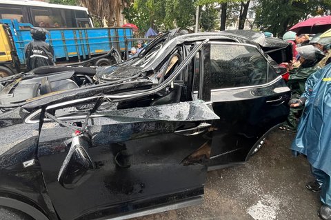 Sebuah mobil mewah Lexus tertimpa pohon tumbang di Jalan Metro Pondok Indah, Jakarta, Minggu (26/10/2025).