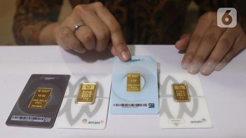 Petugas menunjukkan emas batangan di gerai Butik Emas Antam di Jakarta, Jumat (5/10). Harga emas PT Aneka Tambang Tbk atau Antam naik Rp 1.000 menjadi Rp 666 ribu per gram pada perdagangan ha