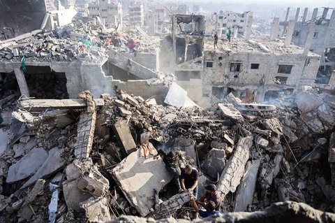 Warga Palestina berusaha mengevakuasi jenazah dari reruntuhan rumah yang hancur akibat serangan udara Israel semalam, di Kota Gaza, Rabu (29/10/2025).