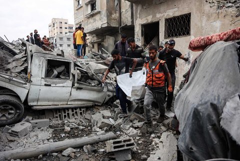 Warga Palestina mengevakuasi  jenasah dari reruntuhan rumah yang hancur akibat serangan udara Israel semalam di Kota Gaza,  Rabu (29/10/2025).