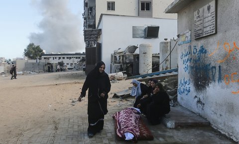 Kerabat duduk di samping jenazah seorang warga Palestina yang tewas dalam serangan tentara Israel di Rumah Sakit Shifa, Rabu (29/10/2025).