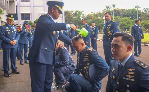 Kaskoopsudnas Marsda TNI Purwoko Aji Pabowo memandikan personie Koops Udara Nasional TNI AU usai upacara kenaikan pangkat di Makoopsudnas, Jakarta, Rabu (1/10/2025).