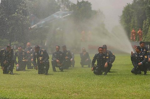 Personel Koops Udara Nasional TNI AU basah kuyup saat dimandikan usai  upacara kenaikan pangkat di Makoopsudnas, Jakarta, Rabu (1/10/2025).