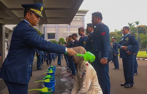 Kaskoopsudnas Marsda TNI Purwoko Aji Pabowo memandikan personie Koops Udara Nasional TNI AU usai upacara kenaikan pangkat di Makoopsudnas, Jakarta, Rabu (1/10/2025).