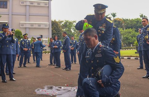 Personel Koops Udara Nasional TNI AU basah kuyup saat dimandikan usai  upacara kenaikan pangkat di Makoopsudnas, Jakarta, Rabu (1/10/2025).