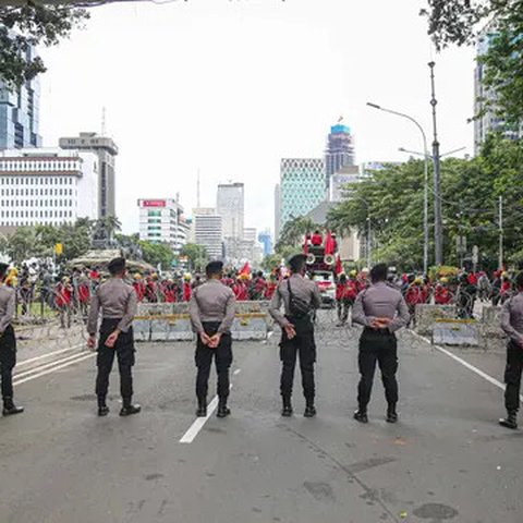 Polisi berjaga saat massa dari berbagai elemen buruh berunjuk rasa di kawasan Patung Kuda, Jakarta, Kamis (22/10/2020). Dalam aksinya, massa meminta dikeluarkannya Perppu pencabutan UU Cipta