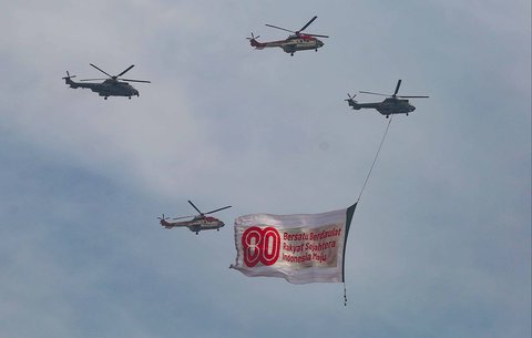 Helikopter TNI AU membawa banner HUT TNI saat gladi bersih Hari Ulang Tahun (HUT) ke-80 Tentara Nasional Indonesia (TNI) di Monas, Jakarta, Jumat (3/10/2025).