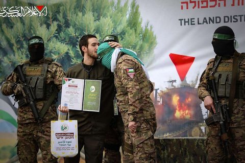 Sandera Israel Omer Shem-Tov mencium kening pejuang Hamas selama upacara pembebasannya yang berlangsung di wulayah Nuseirat, Jalur Gaza tengah, pada 22 Februari 2025.