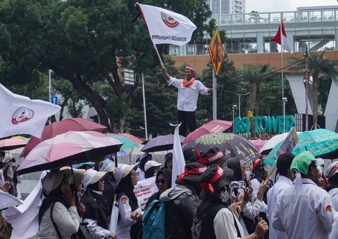 Sejumlah guru honorer madrasah swasta menggelar aksi demonstrasi dengan membawa spanduk tuntutan dan berorasi di Jalan Medan Merdeka Selatan, Gambir, Jakarta Pusat, Kamis (30/10/2025).