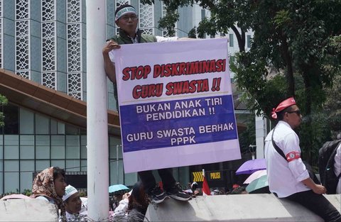 Sejumlah guru honorer madrasah swasta menggelar aksi demonstrasi dengan membawa spanduk tuntutan dan berorasi di Jalan Medan Merdeka Selatan, Gambir, Jakarta Pusat, Kamis (30/10/2025).