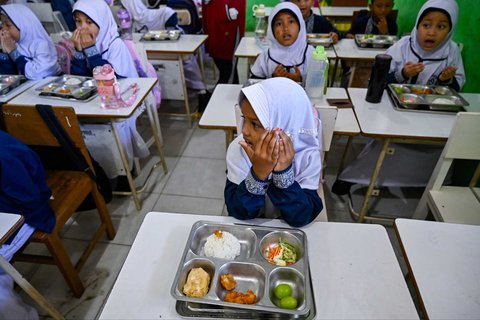 Sejumlah siswa berdoa sebelum menyantap Makanan Bergizi Gratis (MBG) di Sekolah Dasar Negeri 20 Banda Aceh, Aceh, Kamis (30/10/2025).