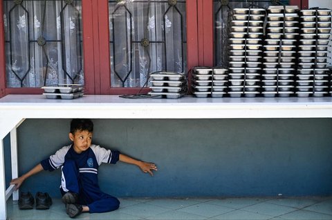 Siswa  bermain di bawah meja nampan Makanan Bergizi Gratis (MBG) di Sekolah Dasar Negeri 20 Banda Aceh, Aceh, Kamis (30/10/2025).