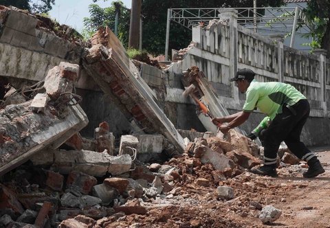 Petugas Sudin Kehutanan DKI melakukan perbaikan tembok pembatas yang roboh di Tempat Pemakaman Umum (TPU) Jeruk Purut, Jakarta Selatan, Kamis (30/10/2025).