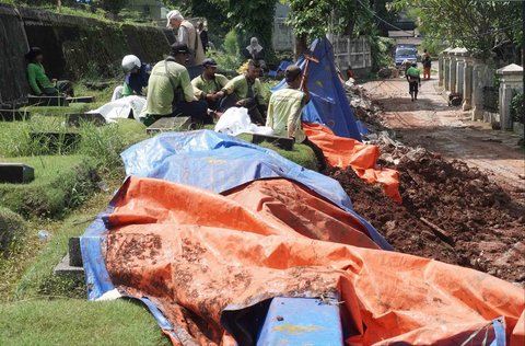 Petugas Sudin Kehutanan DKI melakukan perbaikan tembok pembatas yang roboh di Tempat Pemakaman Umum (TPU) Jeruk Purut, Jakarta Selatan, Kamis (30/10/2025).