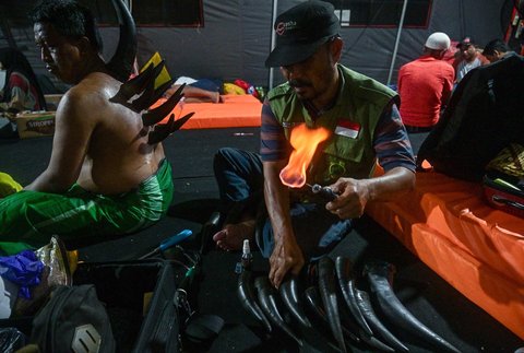 Seorang pria menjalani terapi bekam menggunakan tanduk sapi, yang disediakan oleh para relawan di tenda sementara yang didirikan untuk menampung keluarga santri yang hilang di Rumah Sakit Bhayangkara, Surabaya, Minggu (05/10/2025) malam.